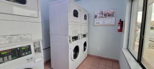 uma lavandaria com máquina de lavar e secar roupa em HomeTowne Studios by Red Roof Egg Harbor-Atlantic City Airport em Egg Harbor Township