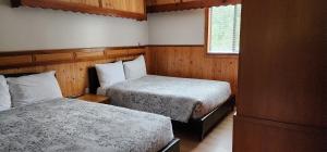 a bedroom with two beds and a window at Meares Vista Inn in Tofino
