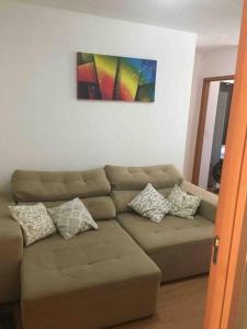 a living room with a brown couch with pillows at APT A 10 MIN DA CIDADE DE PENEDO in Resende