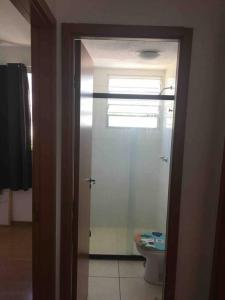 a bathroom with a toilet and a glass door at APT A 10 MIN DA CIDADE DE PENEDO in Resende