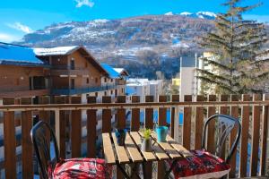 a table and chairs on a balcony with a mountain at BRIANCON - SERRE CHEVALIER 1200 - Joli Appartement - Face aux Pistes en Centre Ville in Briançon