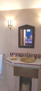 a bathroom with a sink and a mirror at Dar Taliwint in Marrakesh