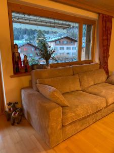 ein Sofa im Wohnzimmer mit einem großen Fenster in der Unterkunft 3 bedroom luxury appartment in Klosters