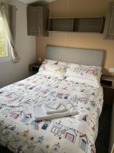 a bed with two towels on top of it at ParkDean Cherry tree holiday park Burgh castle in Belton