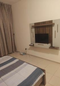 una camera con letto e TV a schermo piatto di Beautiful Master Bedroom in shared apartment ad Ajman