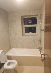 bagno con vasca, servizi igienici e finestra di Beautiful Master Bedroom in shared apartment ad Ajman