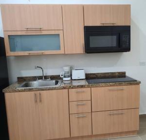 a kitchen with a sink and a microwave at Apartamento para Viajeros 3 in Yabucoa