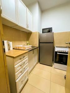 a kitchen with white cabinets and a stainless steel refrigerator at Condo 21 in Belgrade