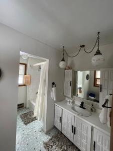 a bathroom with a sink and a mirror and a tub at Breezeway Bay - Waterfront Full House in Wisconsin Dells