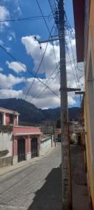 an empty street in a town with mountains in the background at Casa Julia Xela in Quetzaltenango