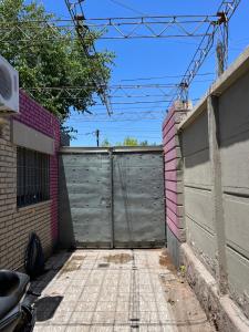 una puerta de garaje en una entrada con una valla en Departamento Especial en Godoy Cruz