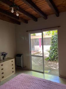 1 dormitorio con puerta corredera de cristal que da a un patio en Departamento Especial en Godoy Cruz