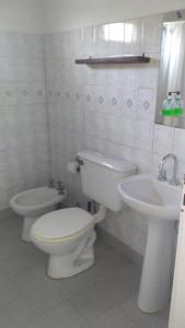 a white bathroom with a toilet and a sink at Boa Vida in Gualeguaychú