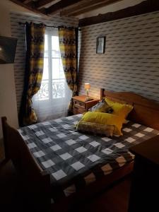 um quarto com uma cama xadrez e uma janela em LOFT Parisien em Paris