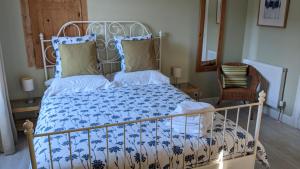 a bedroom with a bed with a blue and white comforter at La Maison Normande in Saint-Cirgues-de-Jordanne
