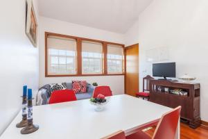 a living room with a white table and red chairs at Apartamentos Lumar in Valença
