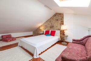a bedroom with a bed and a couch and a chair at Apartamentos Lumar in Valença