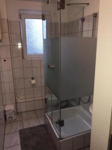 a shower with a glass door in a bathroom at Kölner Pension in Cologne