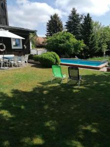 2 sillas y una mesa de billar en un patio en Pension Weidengrund, en Walsrode