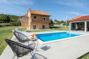 een villa met een zwembad en een huis bij Kuća za odmor s bazenom Marijana in Trilj