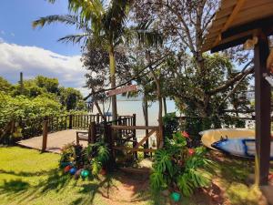 a house with a fence and plants in front of the water at Pousada Encantos do Paraíso in Praia do Rosa