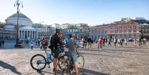 un grupo de personas de pie en una bicicleta en una ciudad en Relais del mar- luxury penthouse with terrace, en Nápoles