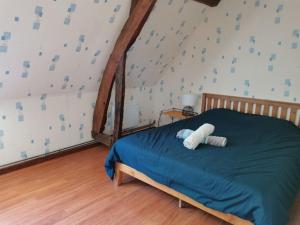 una camera da letto con un letto con lenzuola blu e un muro di Maison normande rénovée proche mer et forêt a Martin-Église
