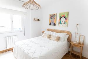 een witte slaapkamer met een groot wit bed en een raam bij Leonor&Pablo in Oviedo