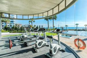a gym with a row of cardio machines in a building at Lux Apartment Punta Prima, Spain in Punta Prima