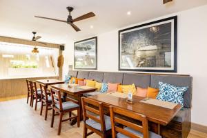 a dining room with two tables and a couch at Cafe Playa Negra Hotel in Playa Negra