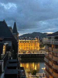 サン・セバスティアンにあるDecor en Gros con vistas al ríoの川の隣の黄色い建物の眺め