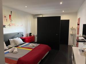 a bedroom with a bed with a red blanket at Sea Breeze Studios in Porto da Cruz