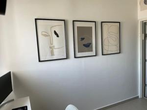 four framed pictures on a white wall at Blue Sea Angels - Luxury appartment Front Sea in Netanya