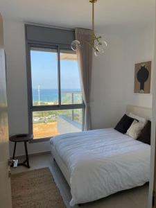 a bedroom with a bed and a large window at Blue Sea Angels - Luxury appartment Front Sea in Netanya