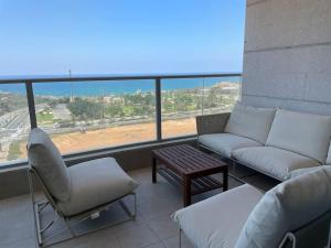 a balcony with a couch and chairs and a table at Blue Sea Angels - Luxury appartment Front Sea in Netanya