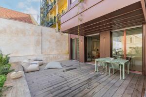 a patio with a table and chairs on a building at Deluxe 2BDR Apartment W/ Patio by LovelyStay in Lisbon