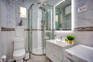 a bathroom with a shower and a toilet and a sink at Marais Appart Haussmannien Neuf Clim & Ascenseur in Paris