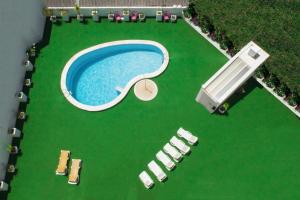 an overhead view of a pool with lawn chairs and a swimming pool at Hotel Cristal Caldas in Caldas da Rainha