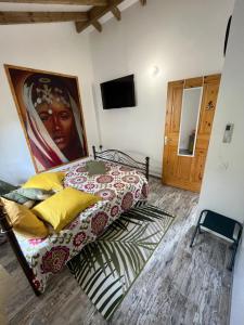 1 dormitorio con 1 cama con una pintura en la pared en Bienvenue chez Angie, en Les Abymes