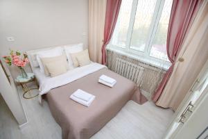 1 dormitorio pequeño con 1 cama con 2 toallas en Уютная студия на Арбате, en Almaty