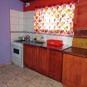 a kitchen with a stove and a sink and a window at Cabaña Don Lorenzo in Puerto Victoria