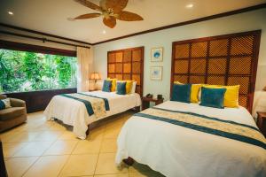 a bedroom with two beds and a window at Hotel Bosque del Mar Playa Hermosa in Playa Hermosa +54 photos