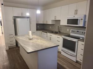 a kitchen with white cabinets and a white refrigerator at Winnipeg Peace Home in Winnipeg