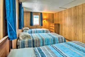 two beds in a room with wooden walls at Pet-Friendly Finger Lakes Home Near Ithaca! 