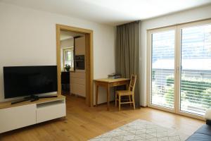 a living room with a flat screen tv and a table at Ferienwohnung Wallner in Niedernsill