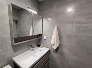 W łazience znajduje się umywalka i lustro. w obiekcie Sweet & Cosy Αpartment in Chora's old town w mieście Andros