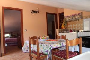 een eetkamer met een tafel en een keuken bij Olmedo Casa Vacanze in Olmedo