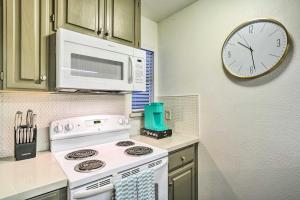 cocina con fogones y reloj en la pared en Graham Haus River Condo Walk to Schlitterbahn! en New Braunfels