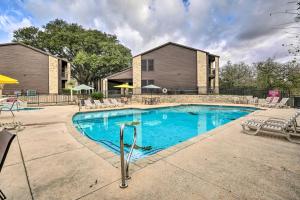 a swimming pool with chairs and a house at Graham Haus River Condo Walk to Schlitterbahn! in New Braunfels