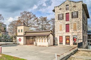 an old stone building with red shutters on a street at Graham Haus River Condo Walk to Schlitterbahn! in New Braunfels